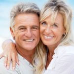 A happy older couple proudly showing off their radiant smiles after a teeth whitening procedure at Andrew Baderski Dental.