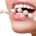 Image of a woman showing off her pearly white teeth after teeth whitening treatment at Andrew Baderski Dental.