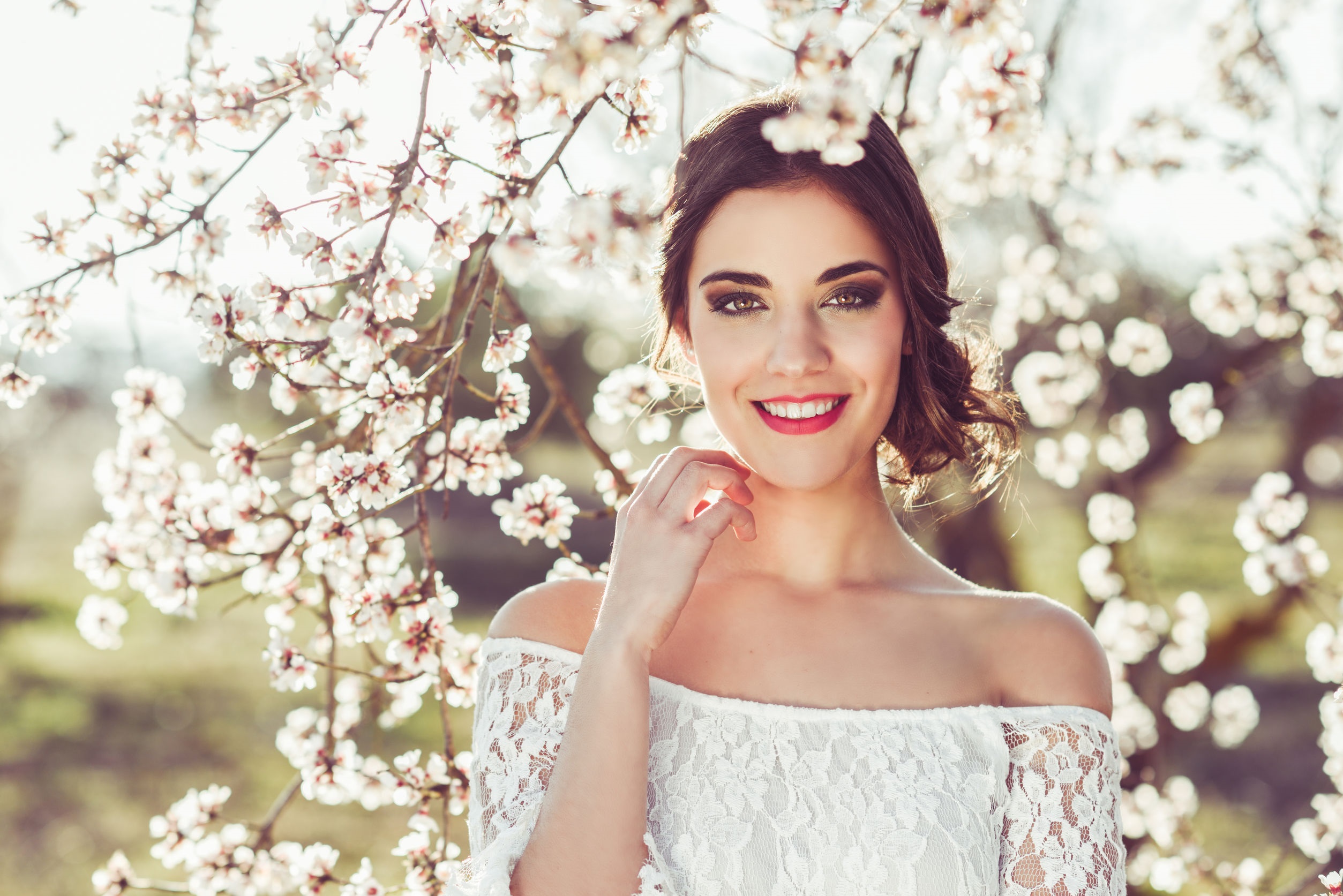 Portrait of young woman in the flowered garden in the spring tim