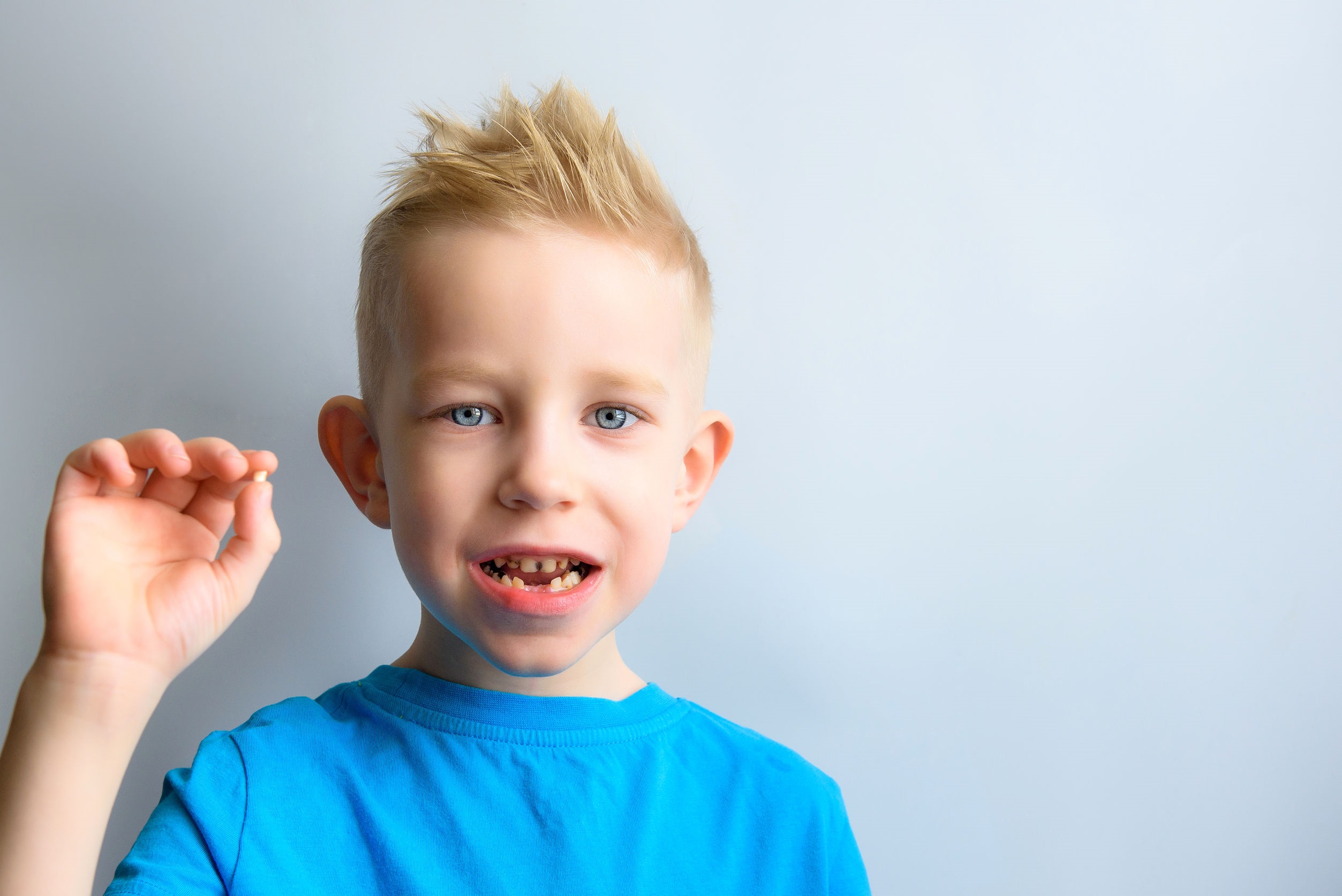 Baby with milk tooth in hands