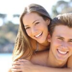 A couple embracing each other, showing the bright smiles on their faces after dental treatment at Andrew Baderski Dental.