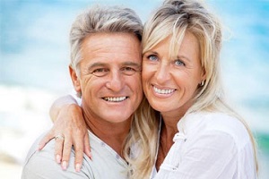 A happy elderly couple is smiling for the camera after receiving dental treatment at Andrew Baderski Dental.