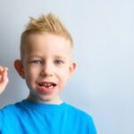 Andrew Baderski Dental - a boy wearing blue shirt smiling
