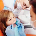 A child is seated for a dental check-up at Andrew Baderski Dental.