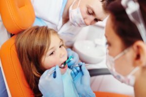 Andrew Baderski Dental - a child sitting while under dental check examination