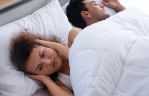 Frustrated woman beside snoring partner—highlighting the value of sleep apnoea solutions from Andrew Baderski Dental